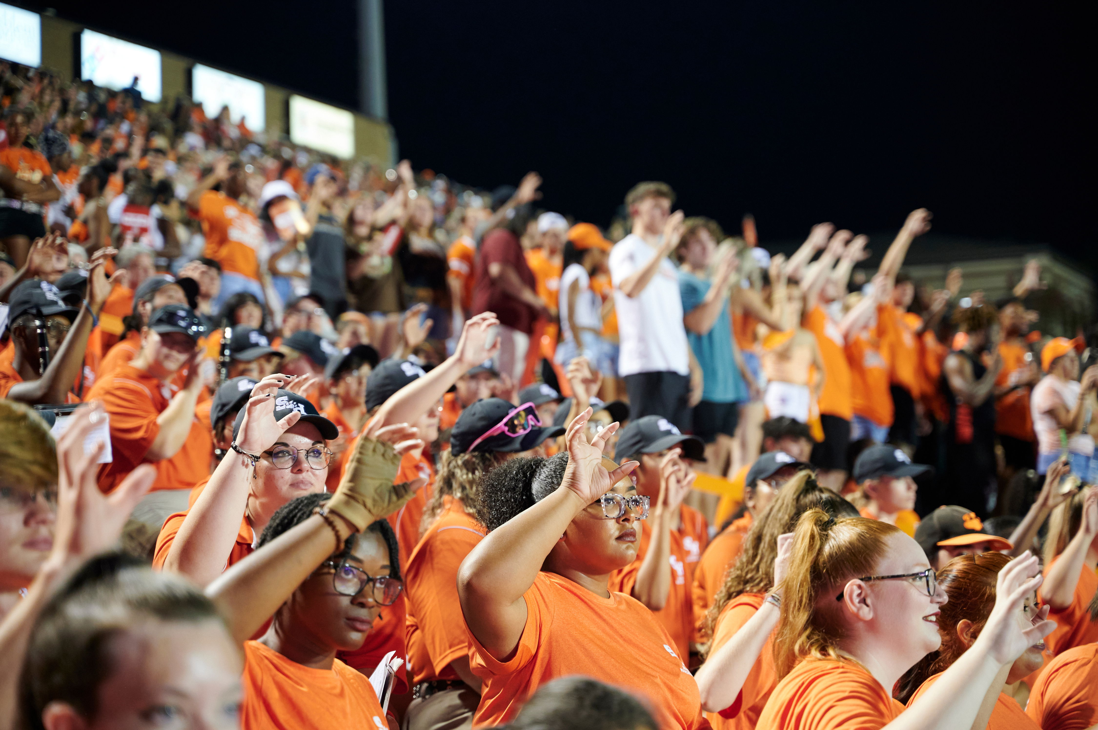 A sea of people in the football stadium, cheering on the team.